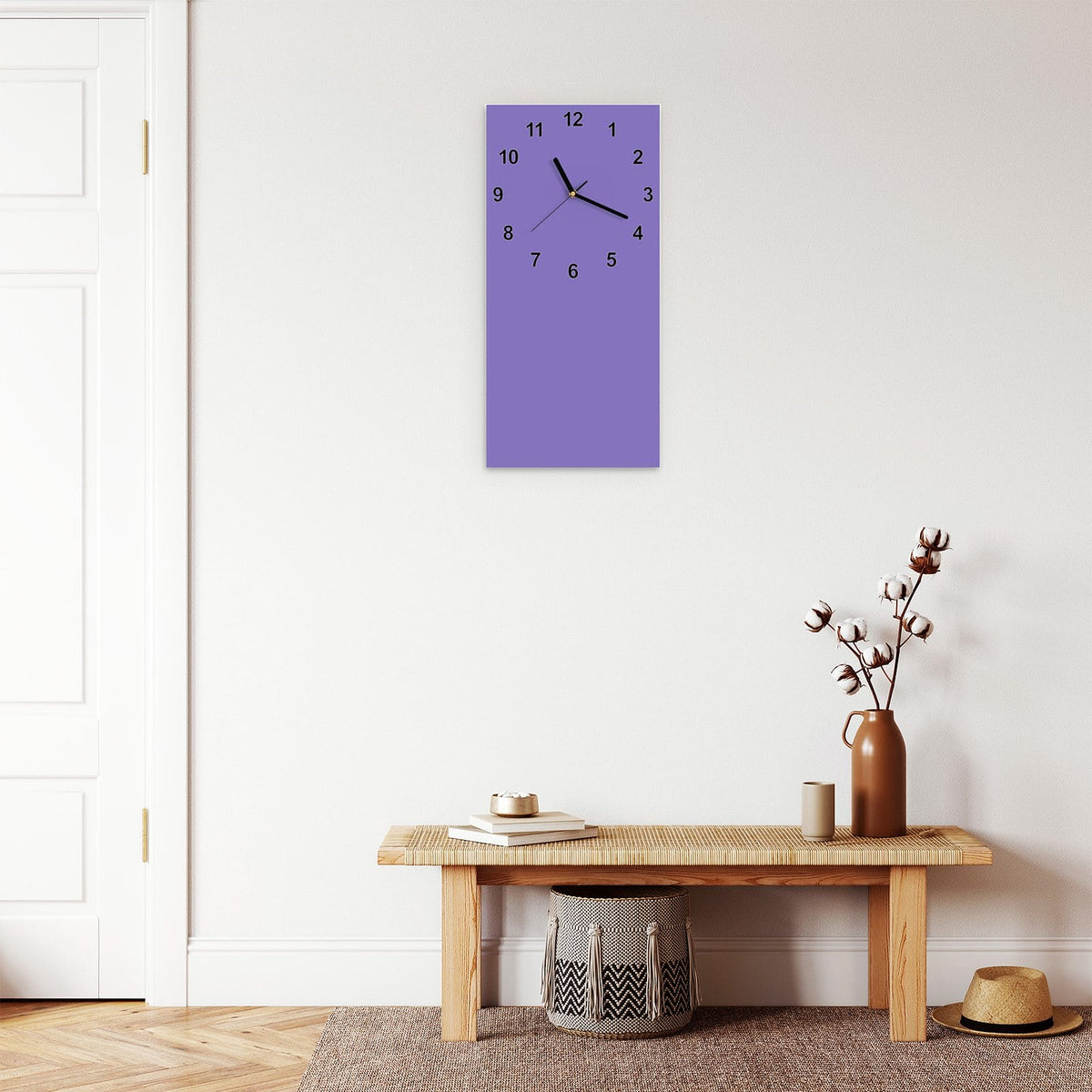 Wanduhr aus Glas im Hochformat Lavendelviolett mit Ziffernblatt Modern über einer Holzbank im Flur