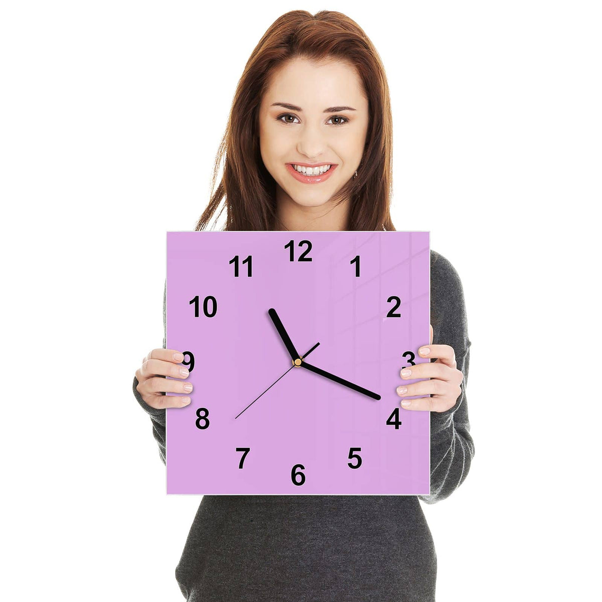 Quadratische Wanduhr aus Glas Fliederlila in zwei Händen gehalten – Größenvergleich, 30 × 30 cm