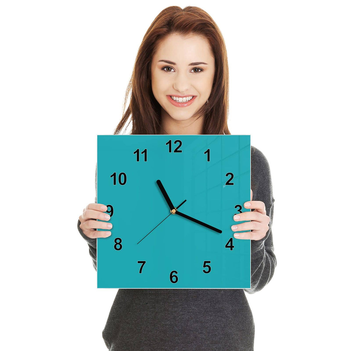 Quadratische Wanduhr aus Glas Lagunentürkis in zwei Händen gehalten – Größenvergleich, 30 × 30 cm