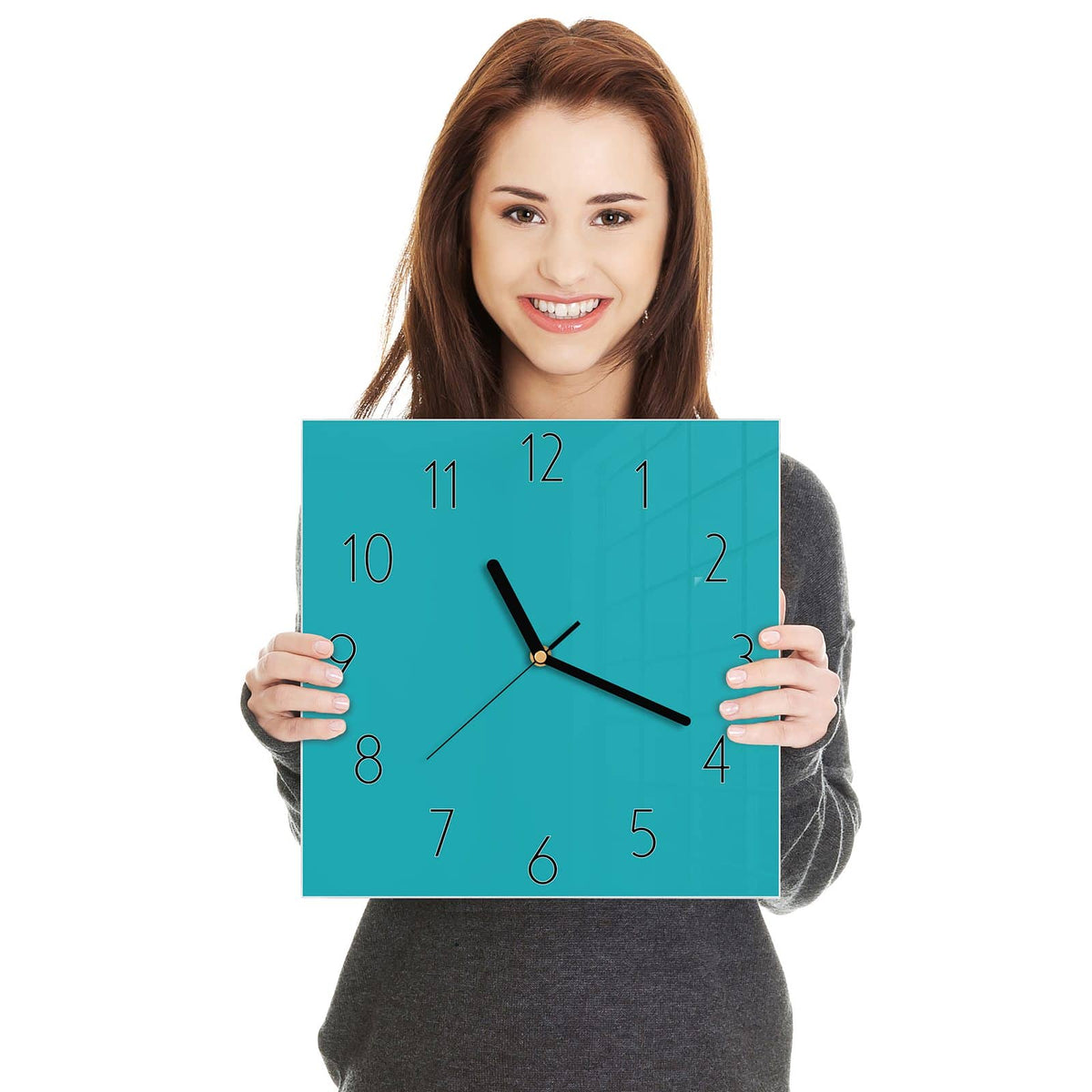 Quadratische Wanduhr aus Glas Lagunentürkis in zwei Händen gehalten – Größenvergleich, 30 × 30 cm