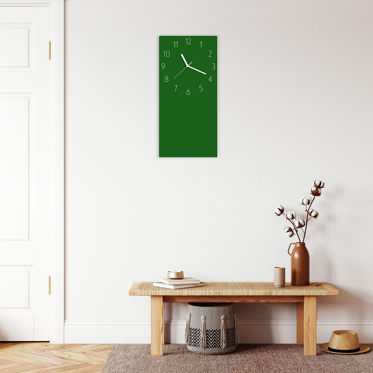 Wanduhr aus Glas im Hochformat Waldgrün mit Ziffernblatt Elegant über einer Holzbank im Flur