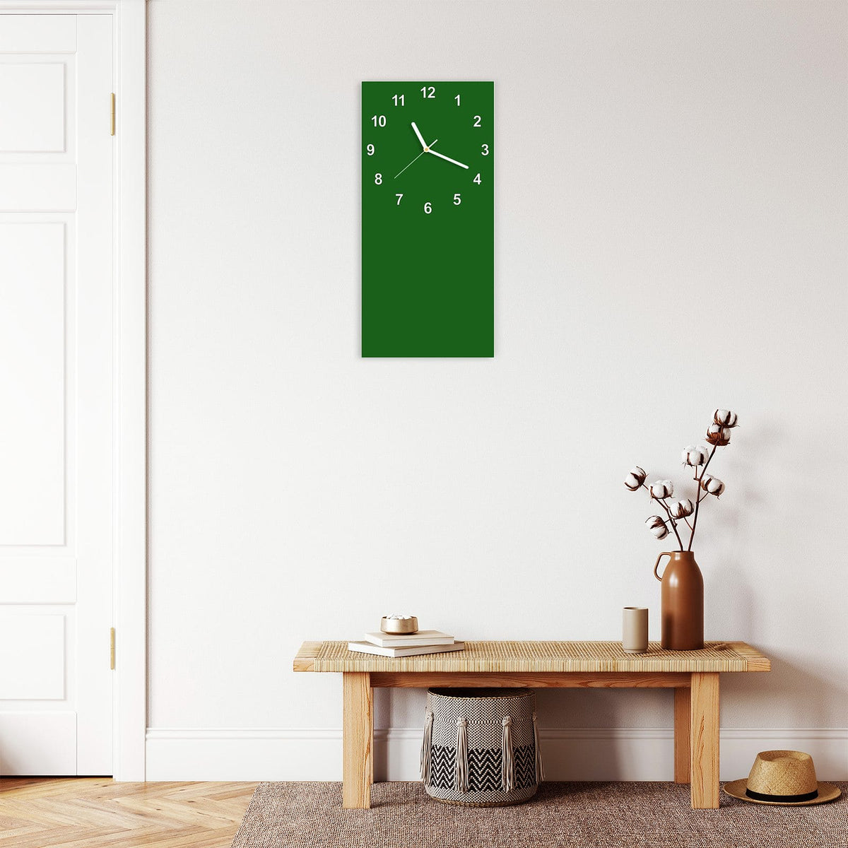 Wanduhr aus Glas im Hochformat Waldgrün mit Ziffernblatt Modern über einer Holzbank im Flur