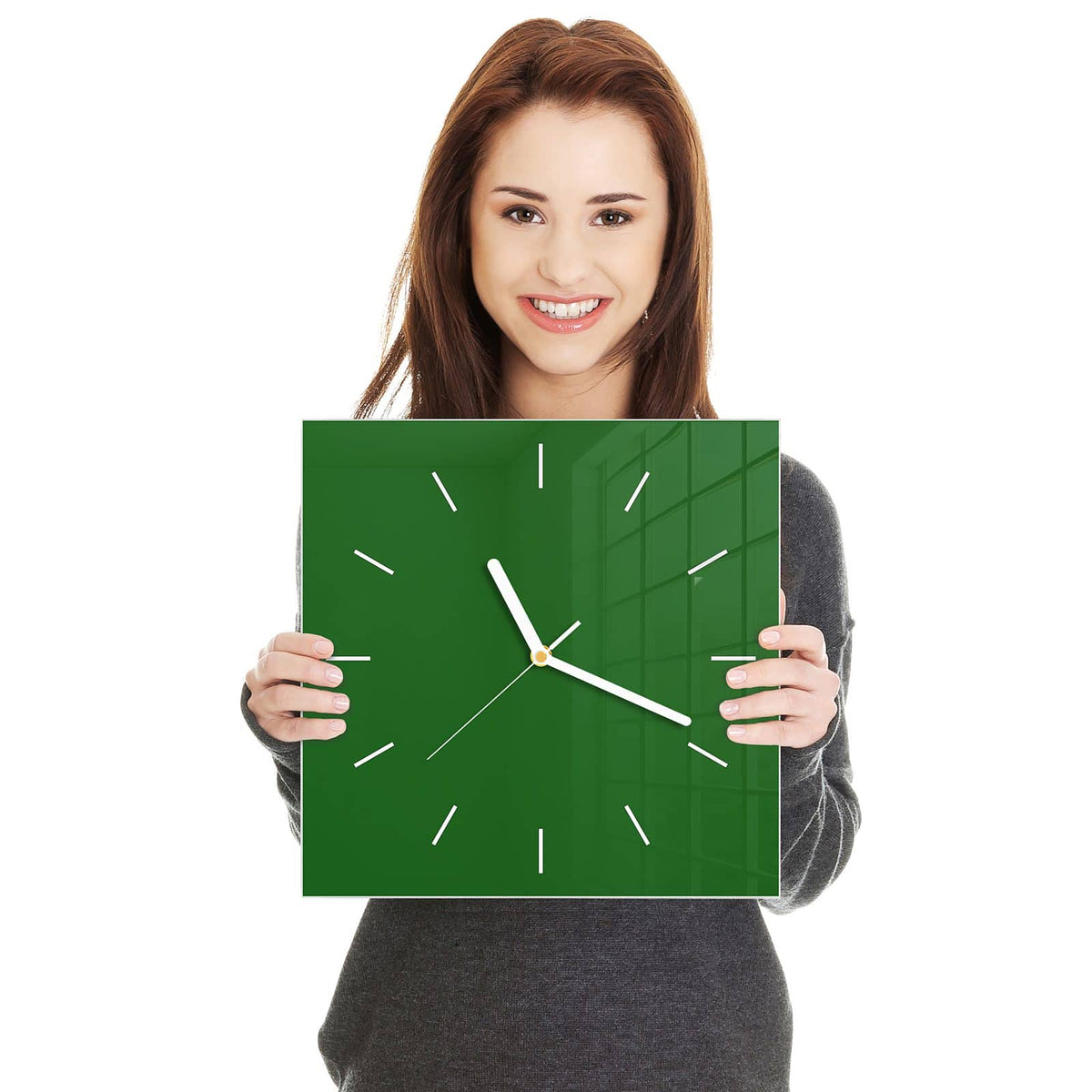 Quadratische Wanduhr aus Glas Waldgrün in zwei Händen gehalten – Größenvergleich, 30 × 30 cm
