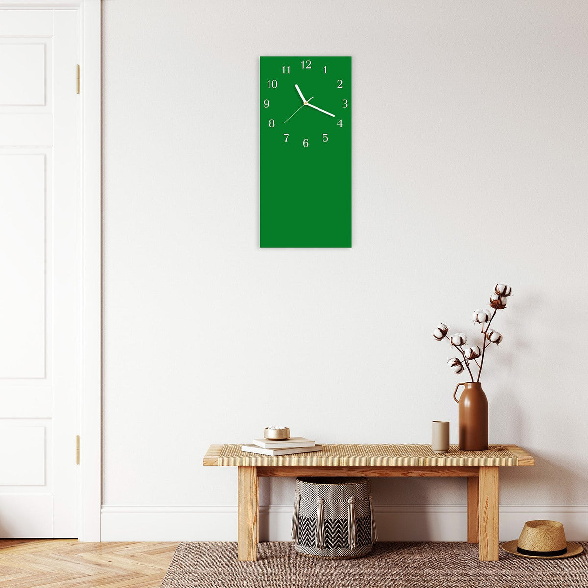 Wanduhr aus Glas im Hochformat Smaragdgrün mit Ziffernblatt Klassisch über einer Holzbank im Flur