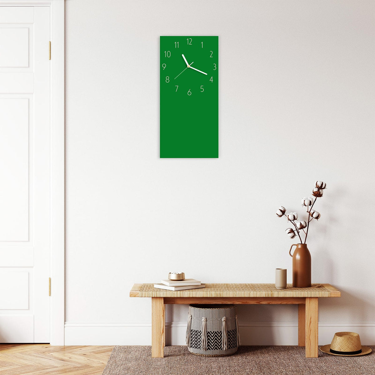 Wanduhr aus Glas im Hochformat Smaragdgrün mit Ziffernblatt Elegant über einer Holzbank im Flur