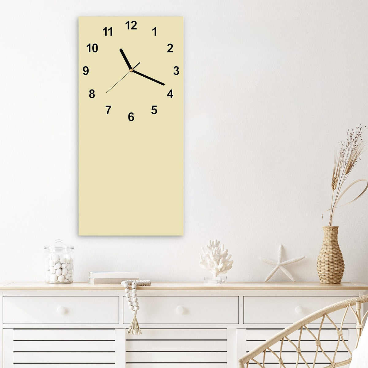 Wanduhr aus Glas im Hochformat Sandbeige mit Ziffernblatt Modern über einem weißen Sideboard