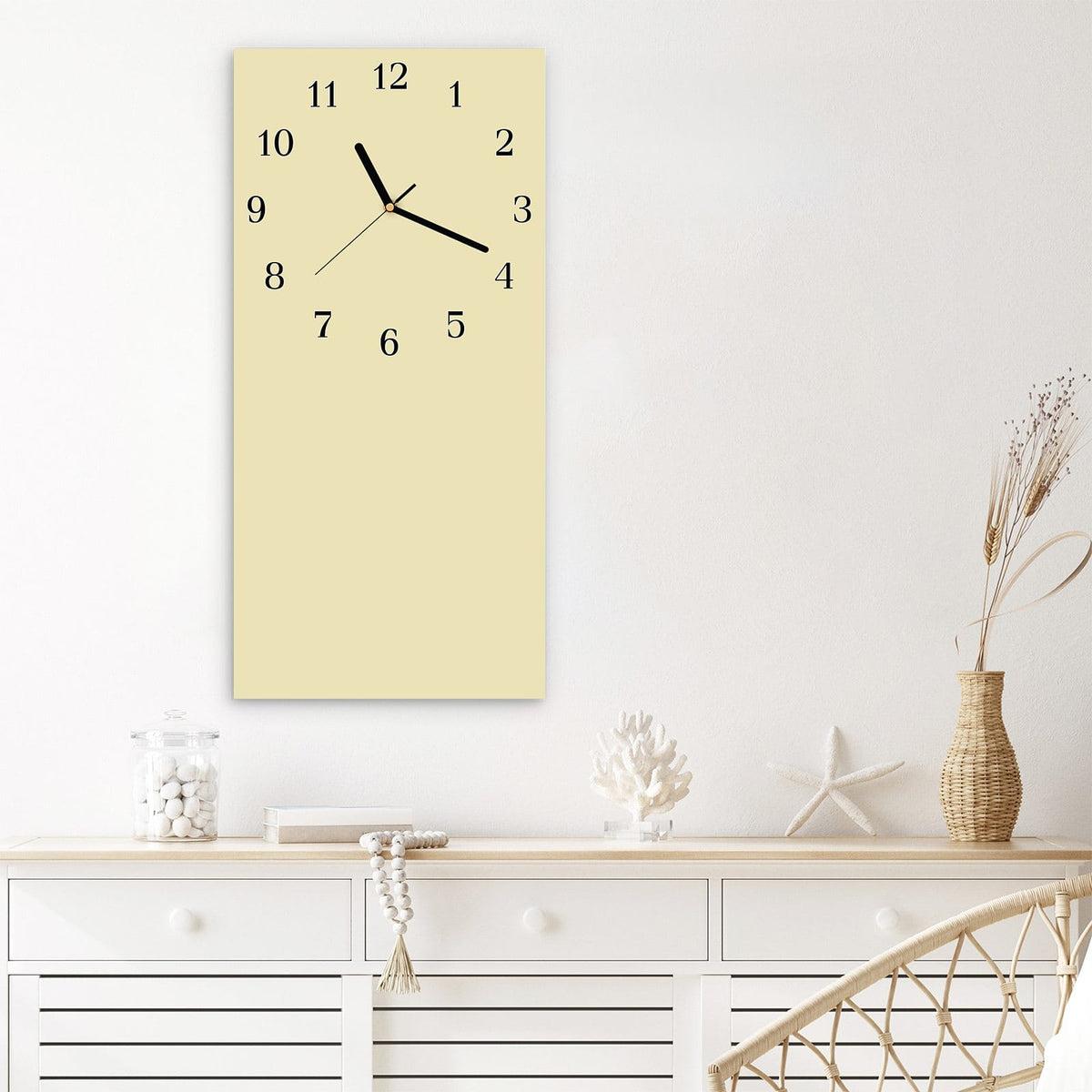 Wanduhr aus Glas im Hochformat Sandbeige mit Ziffernblatt Klassisch über einem weißen Sideboard