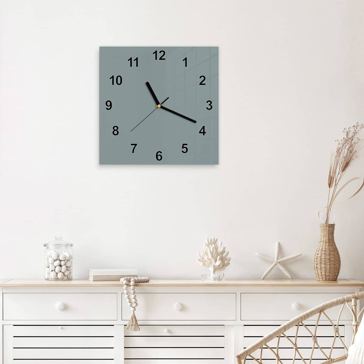 Quadratische Wanduhr aus Glas Steingrau mit Ziffernblatt Modern über einem weißen Sideboard
