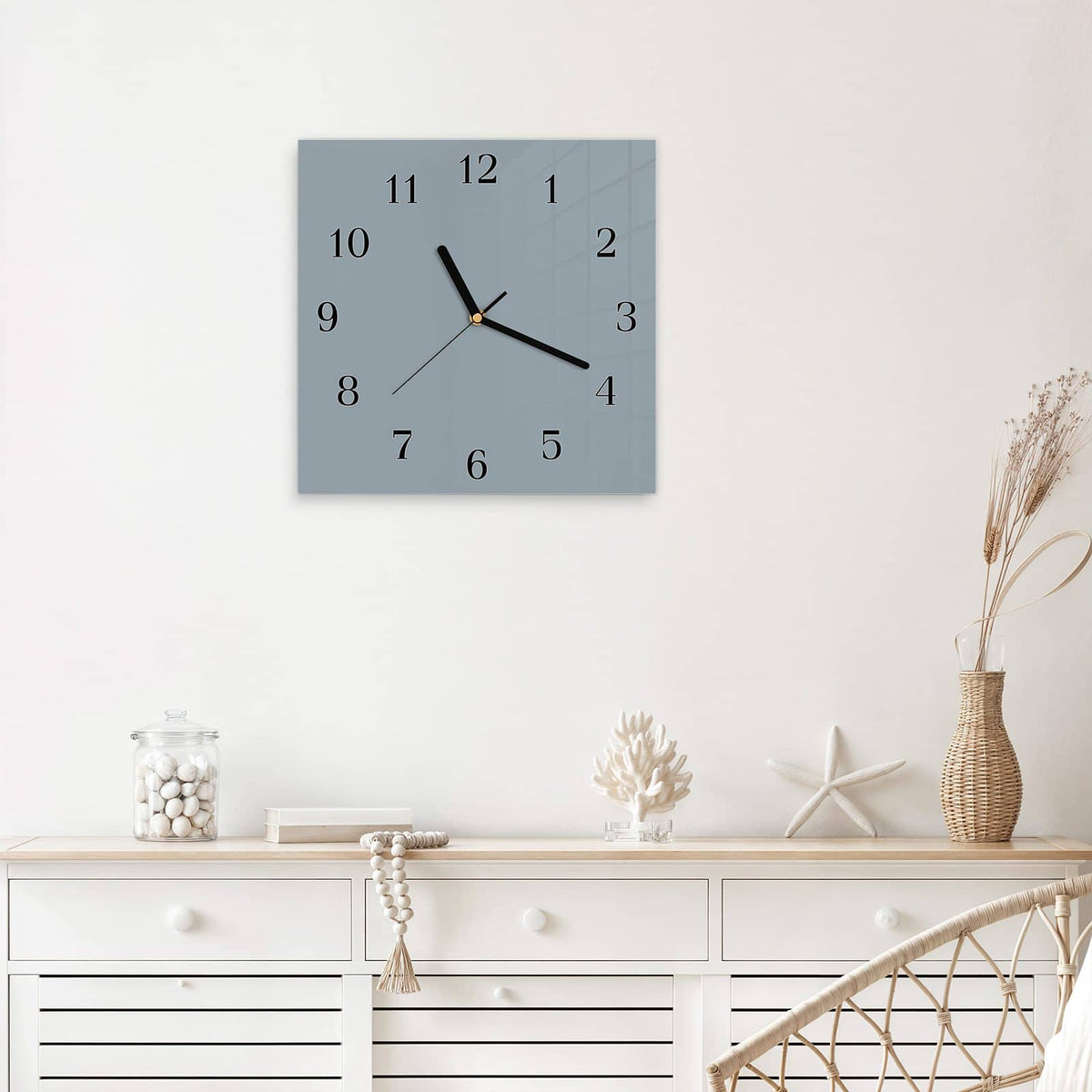 Quadratische Wanduhr aus Glas Schiefergrau mit Ziffernblatt Klassisch über einem weißen Sideboard