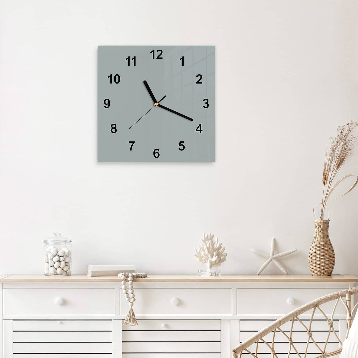 Quadratische Wanduhr aus Glas Nebelgrau mit Ziffernblatt Modern über einem weißen Sideboard