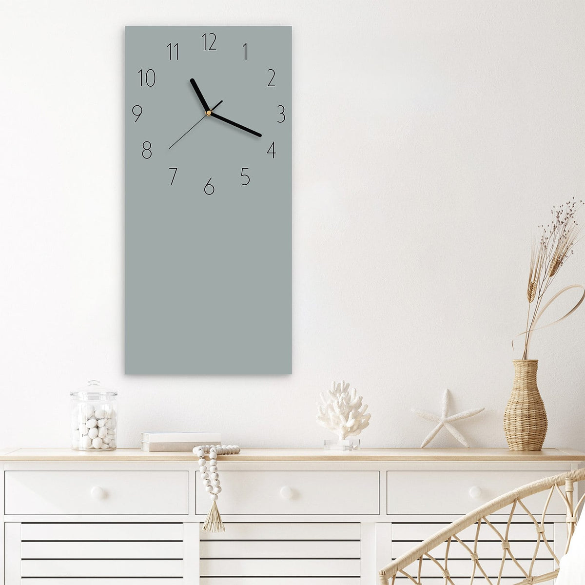 Wanduhr aus Glas im Hochformat Nebelgrau mit Ziffernblatt Elegant über einem weißen Sideboard