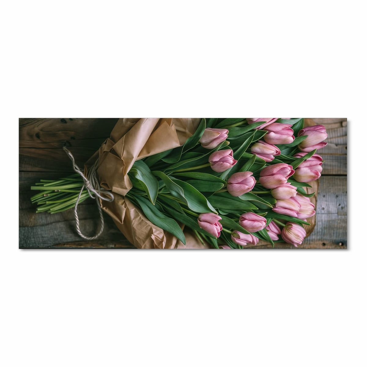 Rosa Tulpen mit grünen Blättern in braunem Packpapier auf Holzdielen