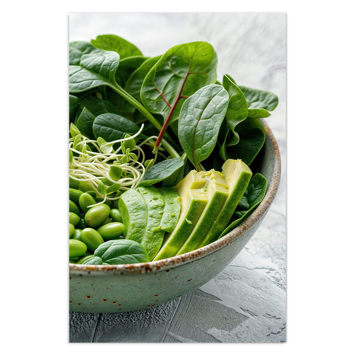 Grüne Schale mit Spinat, Gurke, Edamame, Radieschen und Sprossen, halbe Avocado und Limette daneben