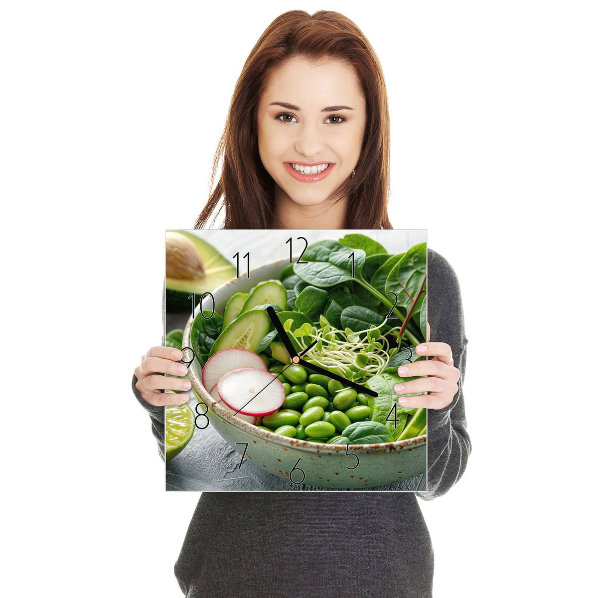 Grüne Schale mit Spinat, Gurke, Edamame, Radieschen und Sprossen, halbe Avocado und Limette daneben