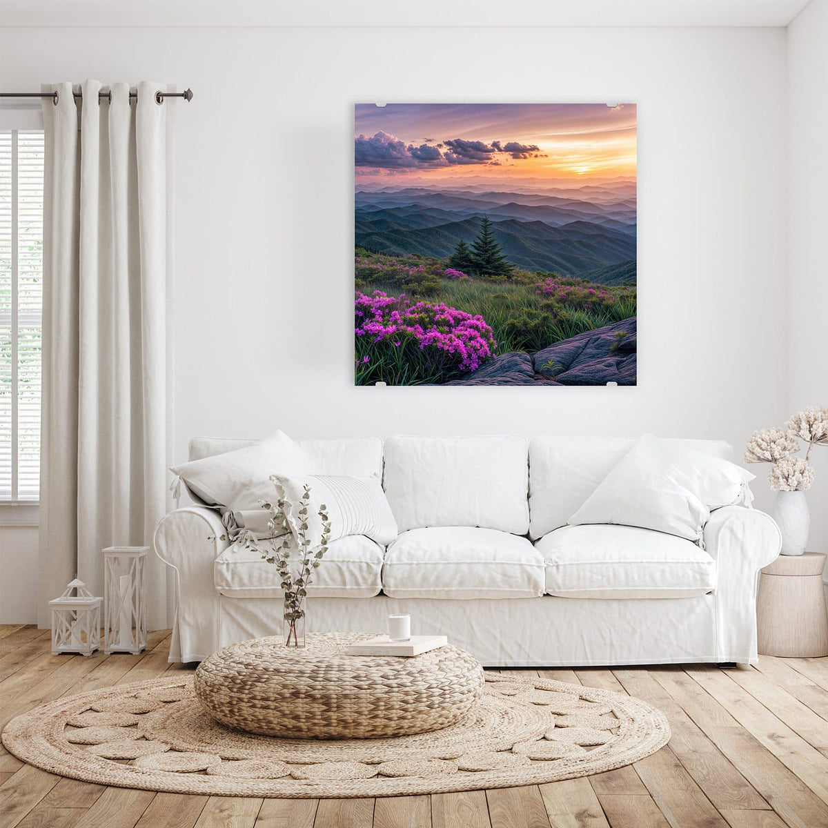 pinke Rhododendronblüten auf einem Bergrücken, dahinter gestaffelte Bergketten im Sonnenuntergang