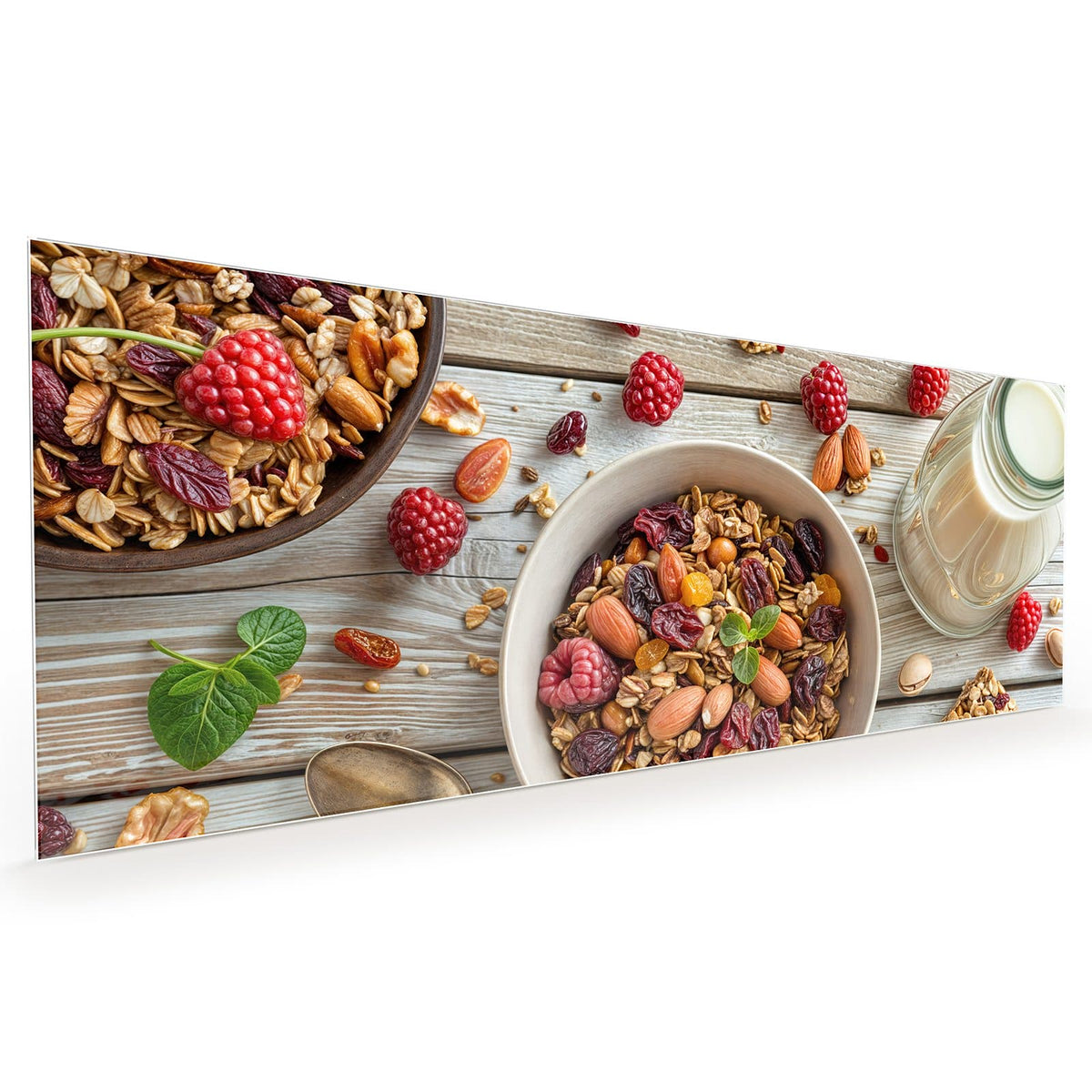 Küchenrückwand aus Glas im Hochformat: Schale mit Granola, Mandeln, Nüssen, Cranberrys und Rosinen auf hellem Holz, dazu Himbeeren, Löffel
