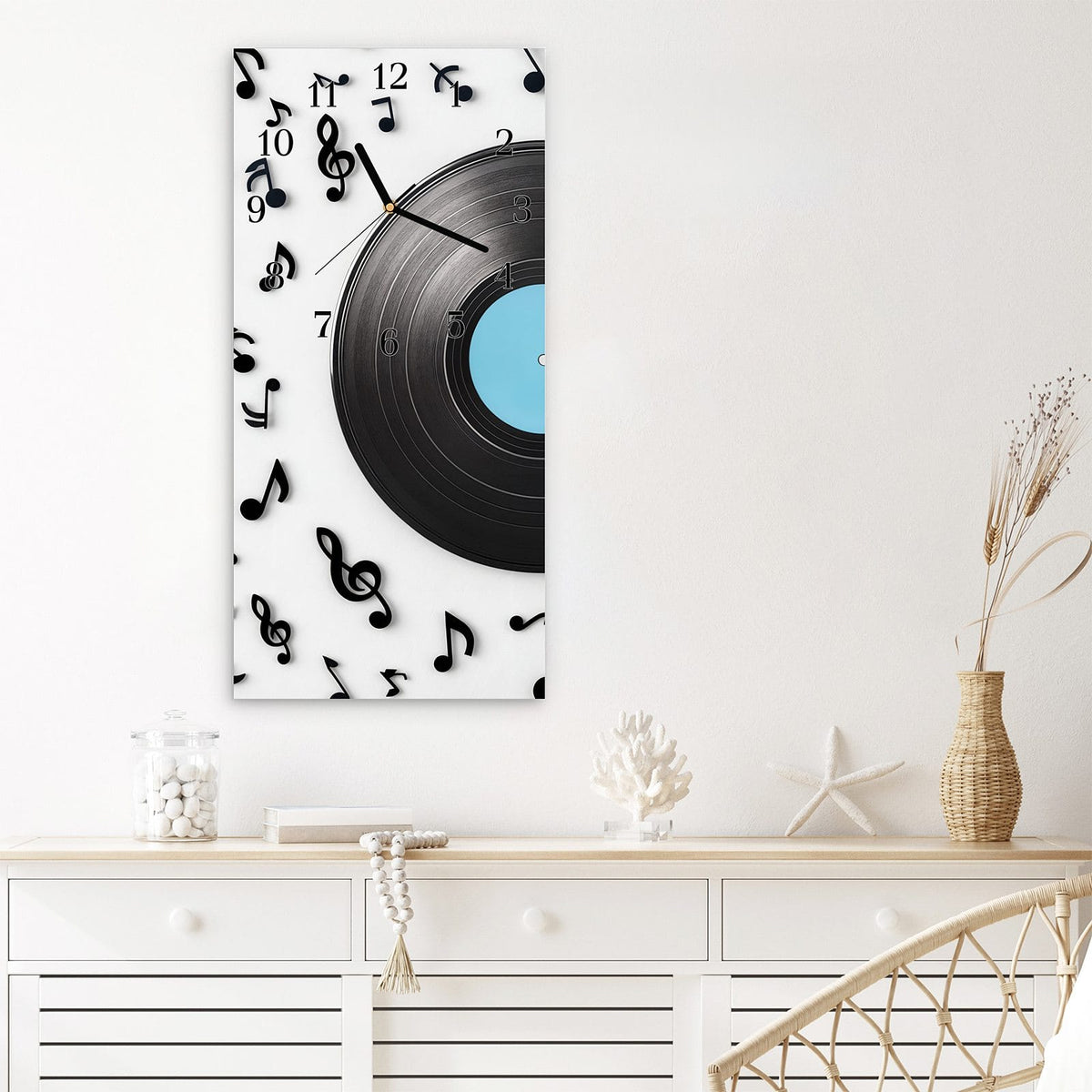 Wanduhr aus Glas im Hochformat Schallplatte mit Noten mit Ziffernblatt Klassisch über einem weißen Sideboard