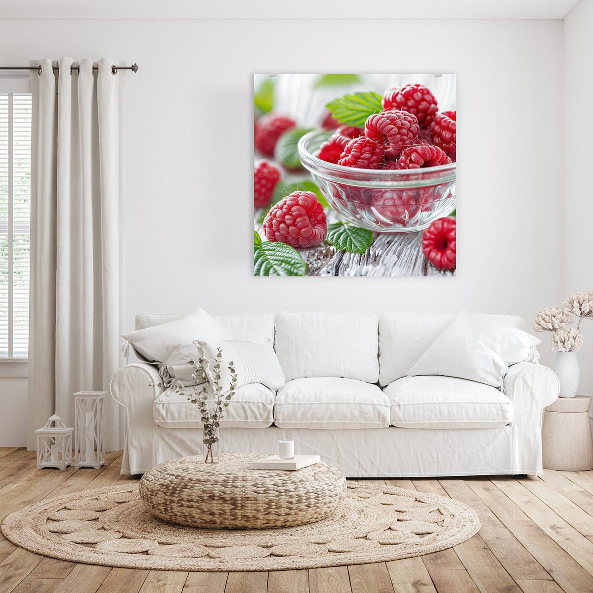 Himbeeren in einer Glasschale auf weiß verwittertem Holz, weitere Beeren und Blätter daneben