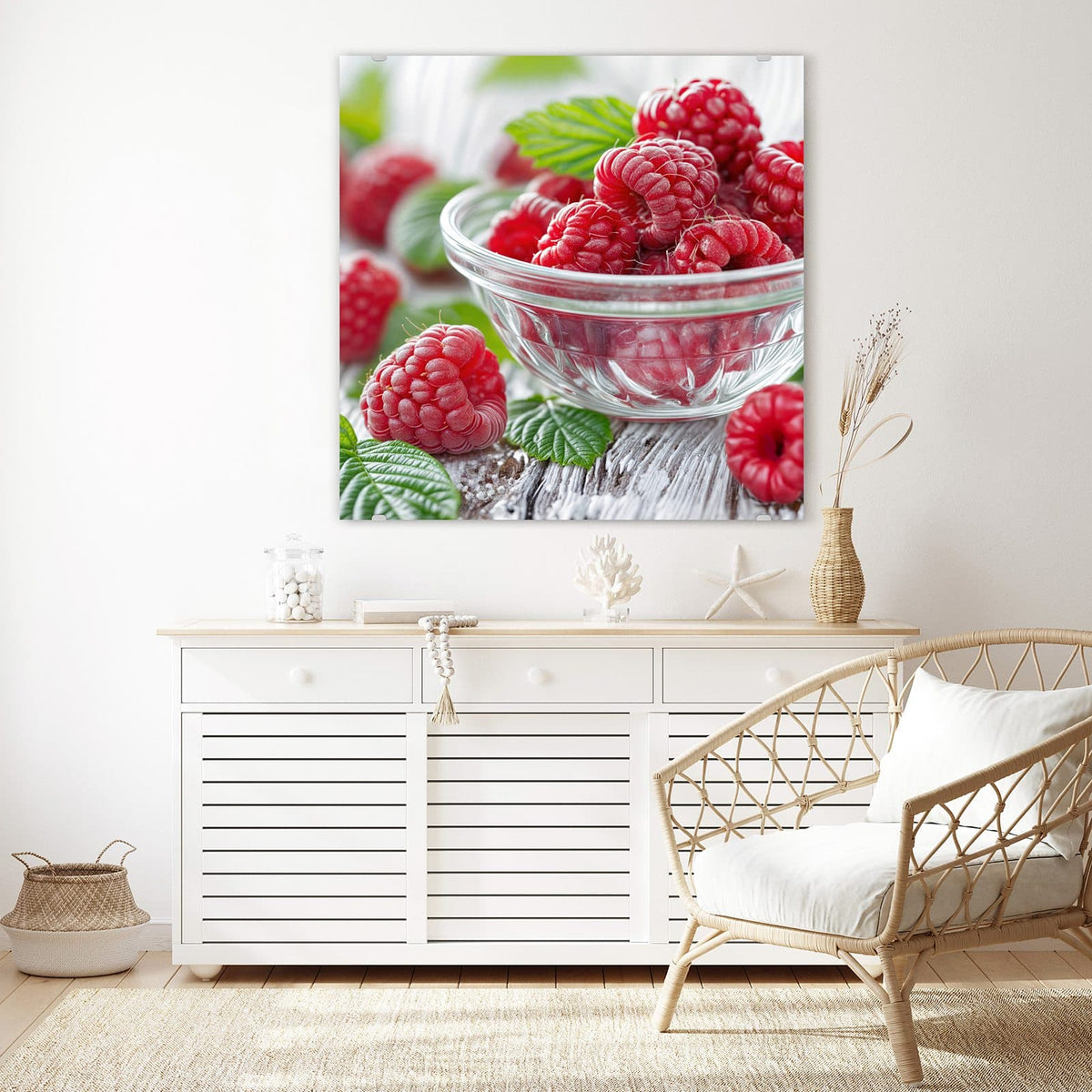 Glasbild Frische Himbeeren an der Wand – Himbeeren in einer Glasschale auf weiß verwittertem Holz, weitere Beeren und Blätter daneben