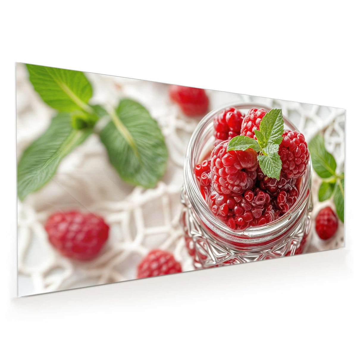 Küchenrückwand aus Glas im Hochformat mit Motiv Glas mit Himbeeren: Einmachglas voller Himbeeren mit Minzblatt auf weißer Spitzendecke
