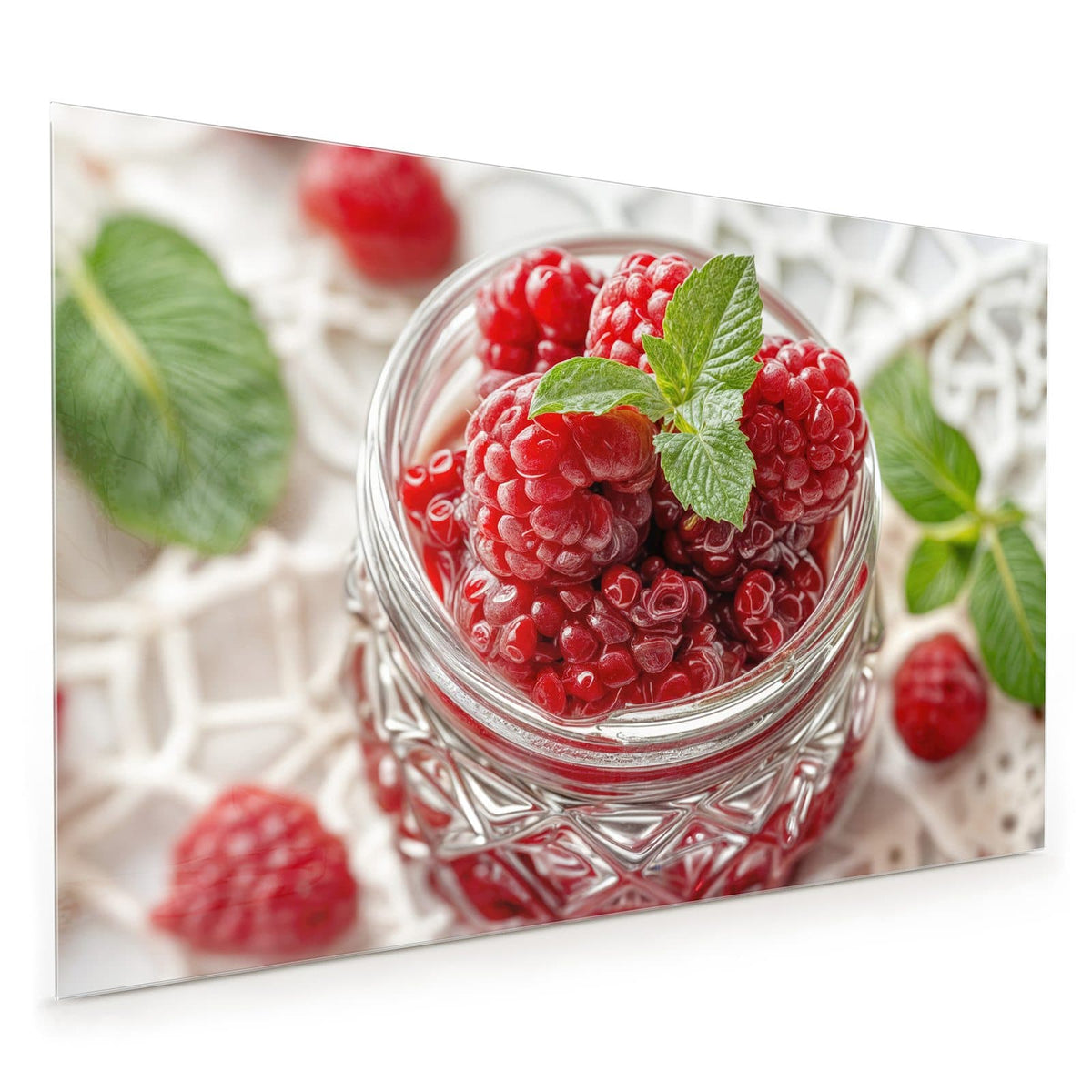 Küchenrückwand aus Glas im Hochformat mit Motiv Glas mit Himbeeren: Einmachglas voller Himbeeren mit Minzblatt auf weißer Spitzendecke