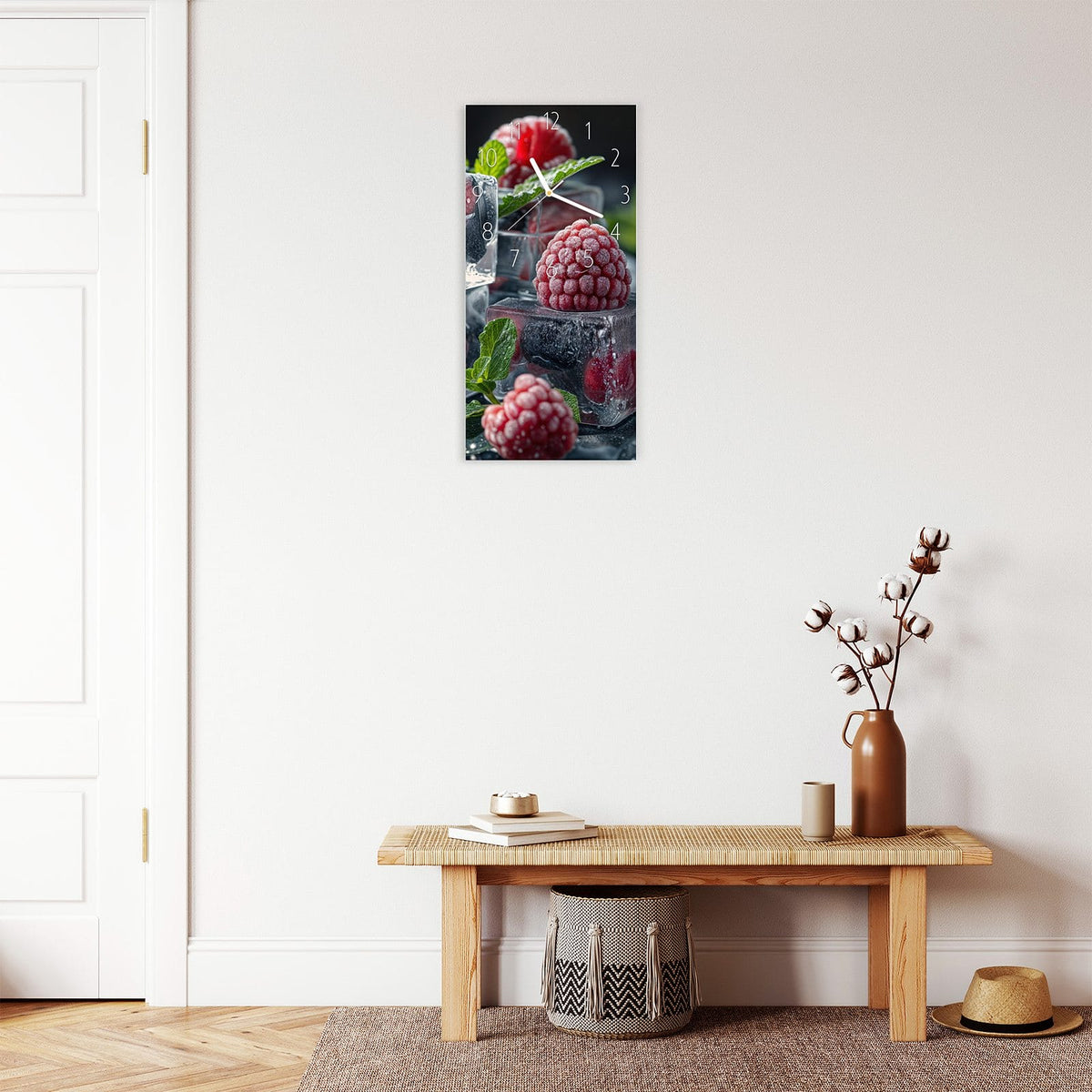 Wanduhr aus Glas im Hochformat Beeren im Eisblock mit Ziffernblatt Elegant über einer Holzbank im Flur