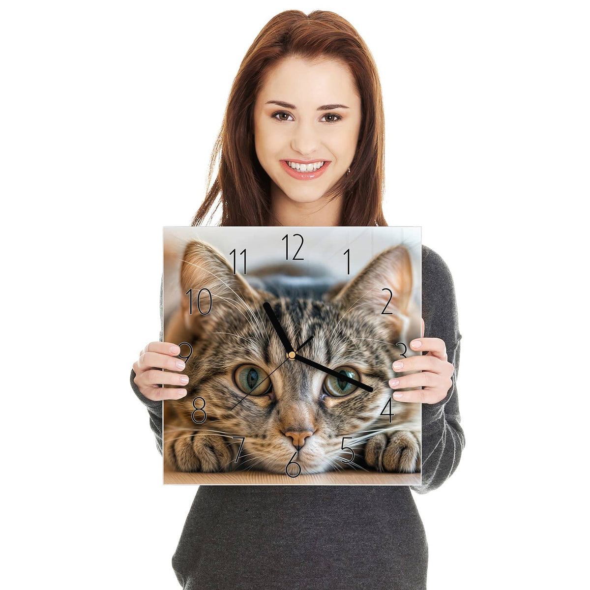 Getigerte Katze liegt flach, Kopf zwischen den Vorderpfoten, große grüne Augen