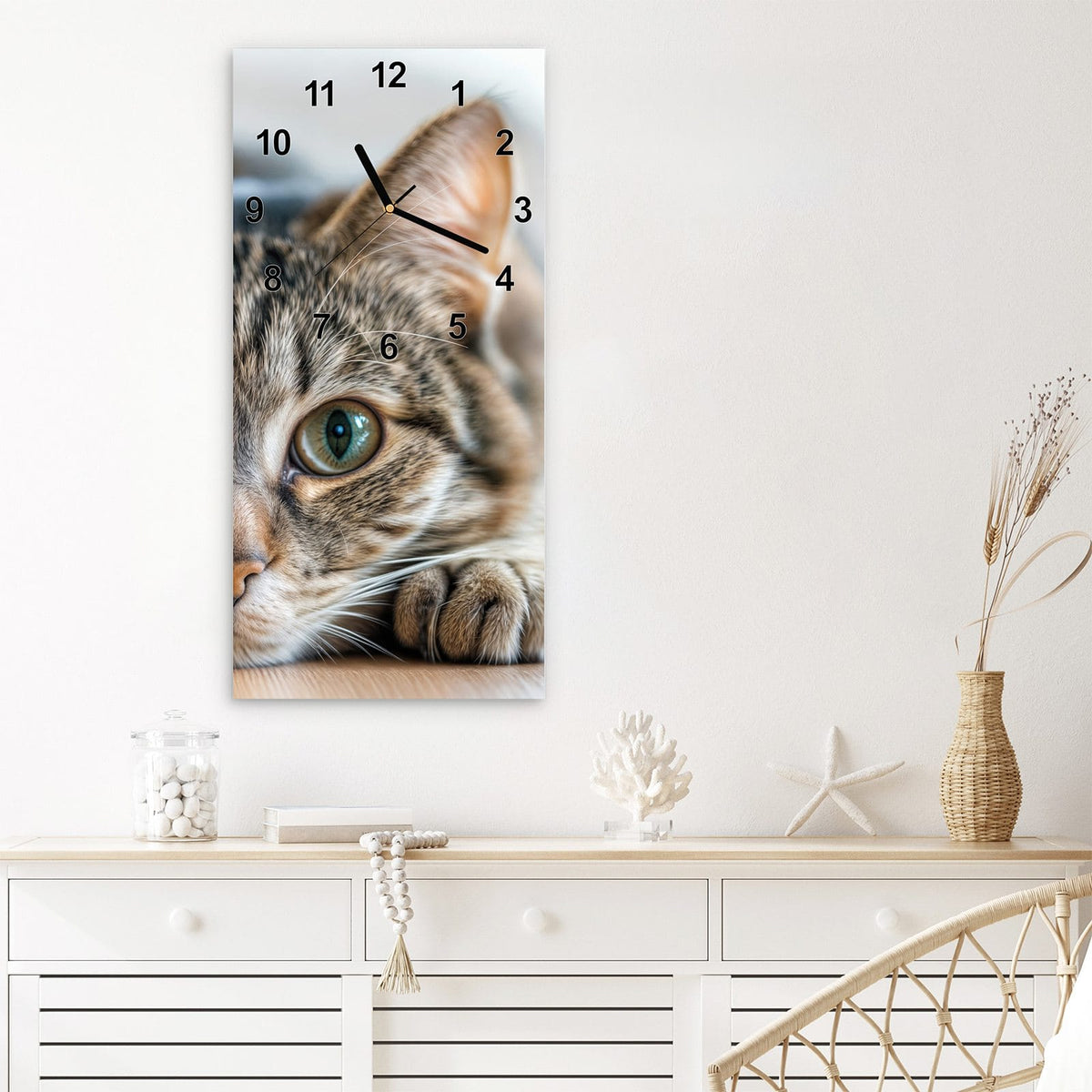 Wanduhr aus Glas im Hochformat Liegende Katze mit Ziffernblatt Modern über einem weißen Sideboard