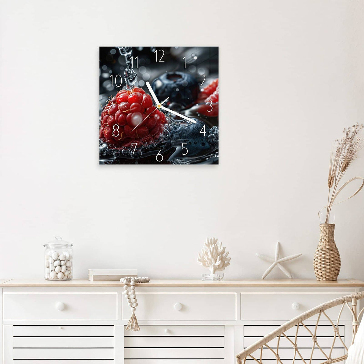 Quadratische Wanduhr aus Glas Himbeere und Blaubeeren mit Ziffernblatt Elegant über einem weißen Sideboard