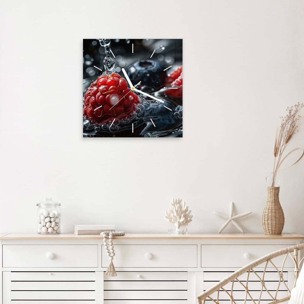 Quadratische Wanduhr aus Glas Himbeere und Blaubeeren mit Ziffernblatt Linie über einem weißen Sideboard