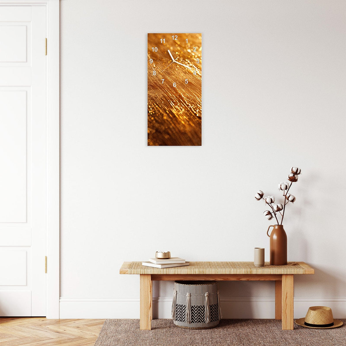Wanduhr aus Glas im Hochformat Schimmerndes Gold mit Ziffernblatt Modern über einer Holzbank im Flur