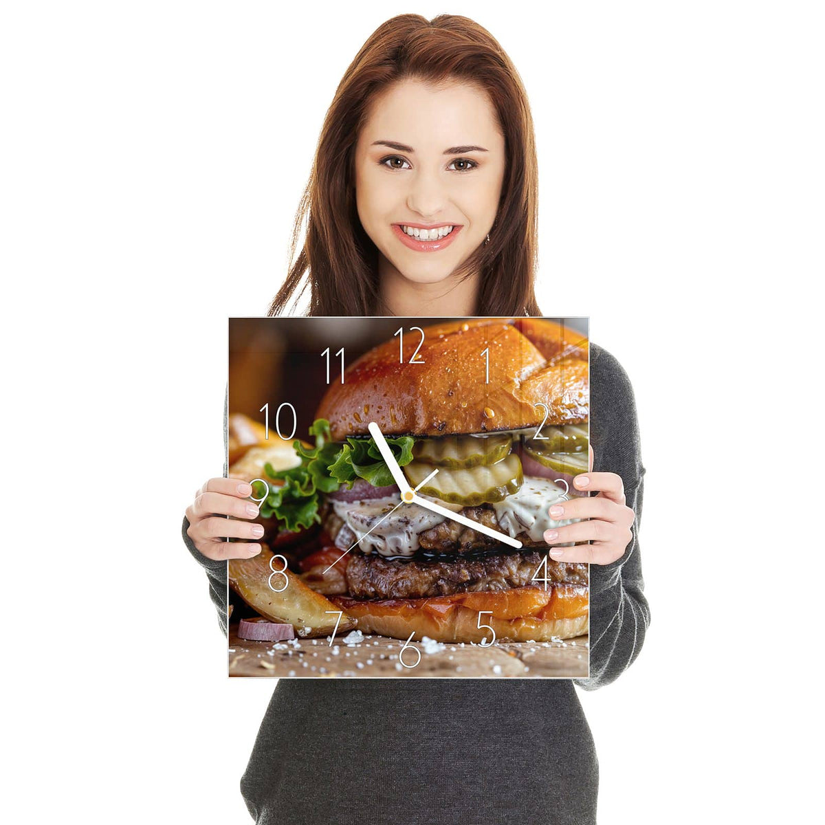 Burger mit Brioche-Bun, Salat, Gurkenscheiben, Zwiebeln und Soße, daneben Kartoffelspalten