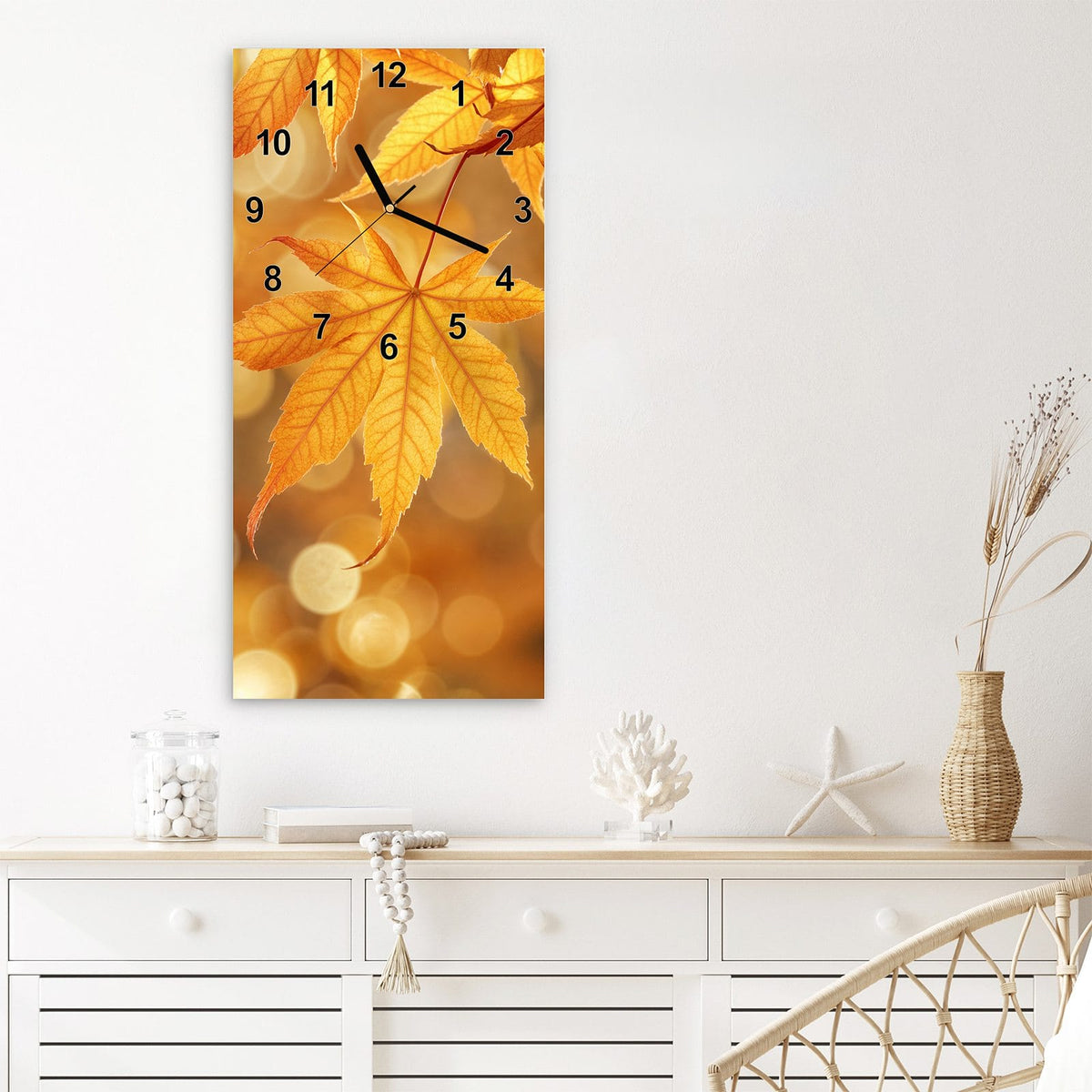 Wanduhr aus Glas im Hochformat Ahorn im Gegenlicht mit Ziffernblatt Modern über einem weißen Sideboard