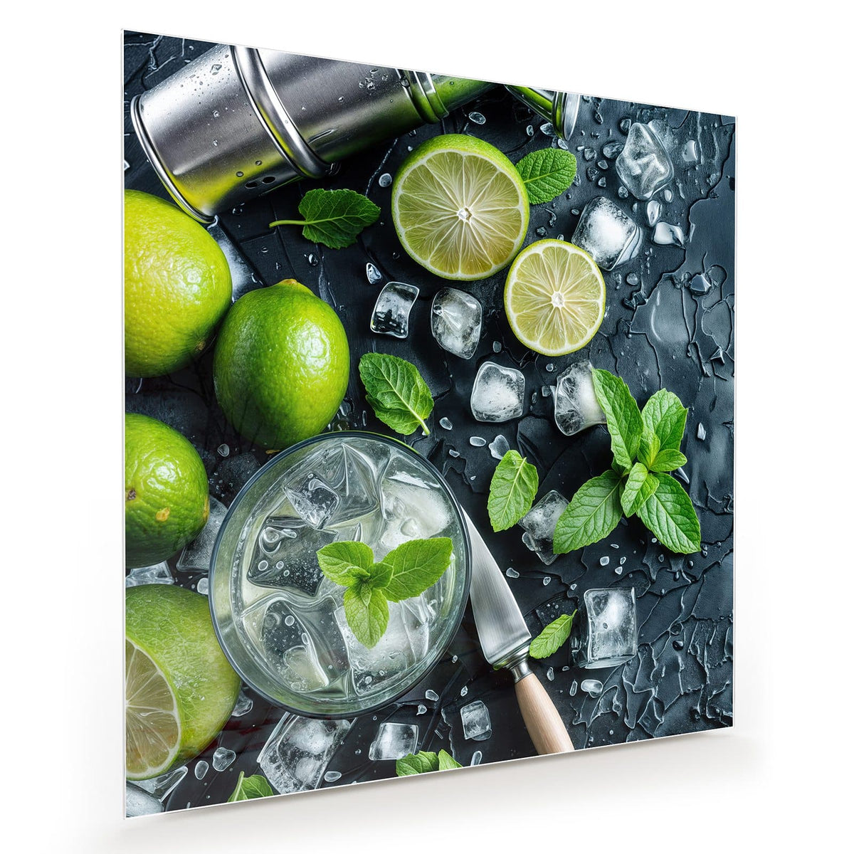 Limetten, Minzblätter und Eiswürfel um ein Glas mit Eis auf nasser dunkler Schieferplatte