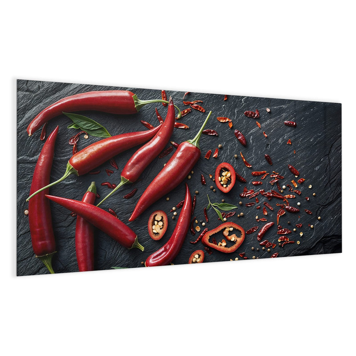 Acht leuchtend rote Chilischoten, einige Ringe und getrocknete Flocken auf dunklem Schiefer