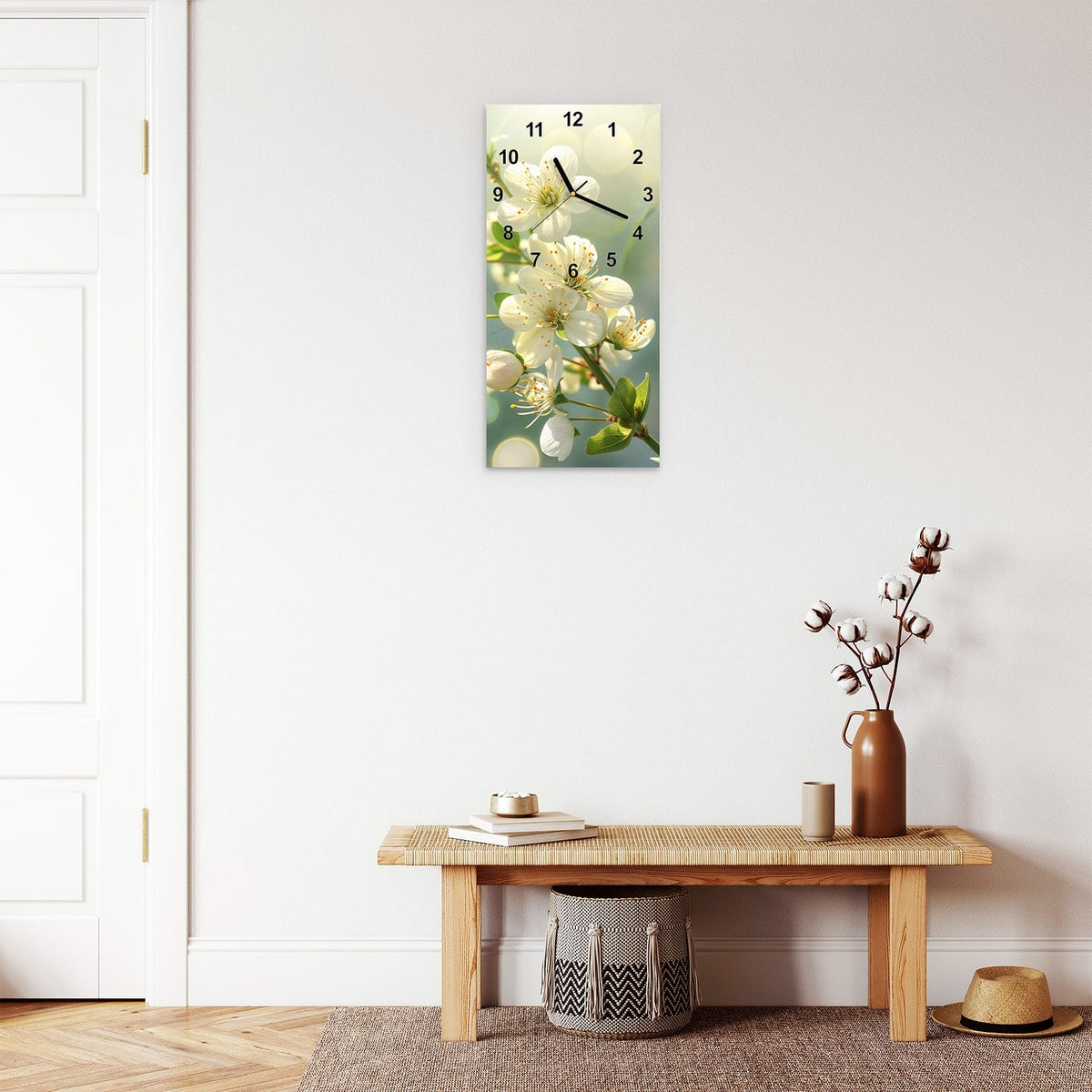 Wanduhr aus Glas im Hochformat Weiße Blüten vor Grün mit Ziffernblatt Modern über einer Holzbank im Flur