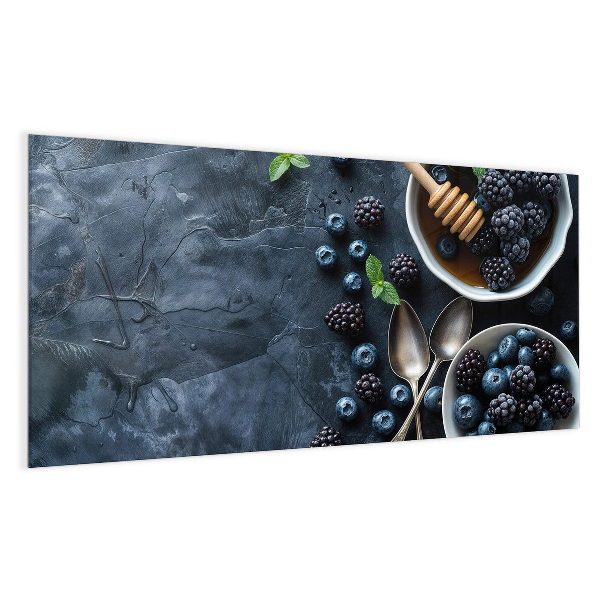 Zwei weiße Schalen mit Heidel- und Brombeeren, Honig mit Honiglöffel, Minze und alte Löffel auf dunklem Schiefer.
