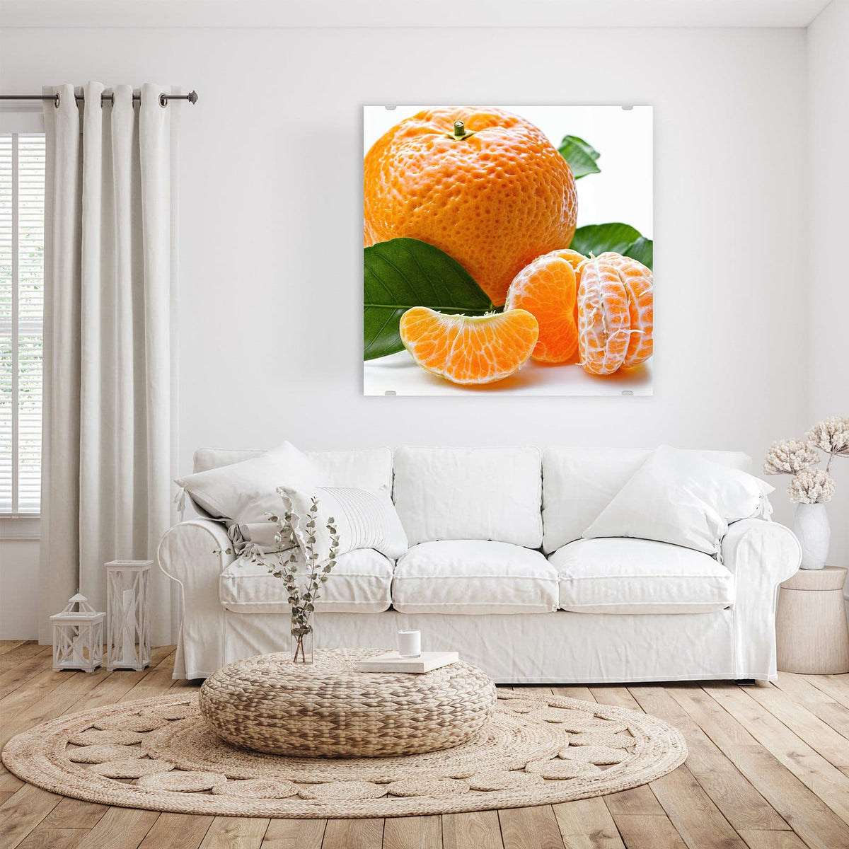 Ganze Mandarine mit grünen Blättern, davor geschälte Frucht und einzelne Spalten vor Weiß