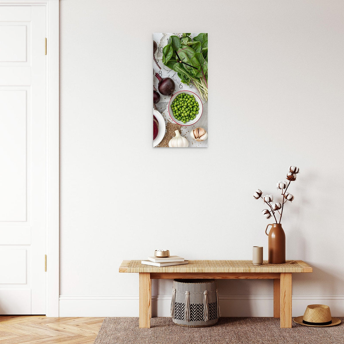 Wanduhr aus Glas im Hochformat Rote Bete und Erbsen mit Ziffernblatt Elegant über einer Holzbank im Flur