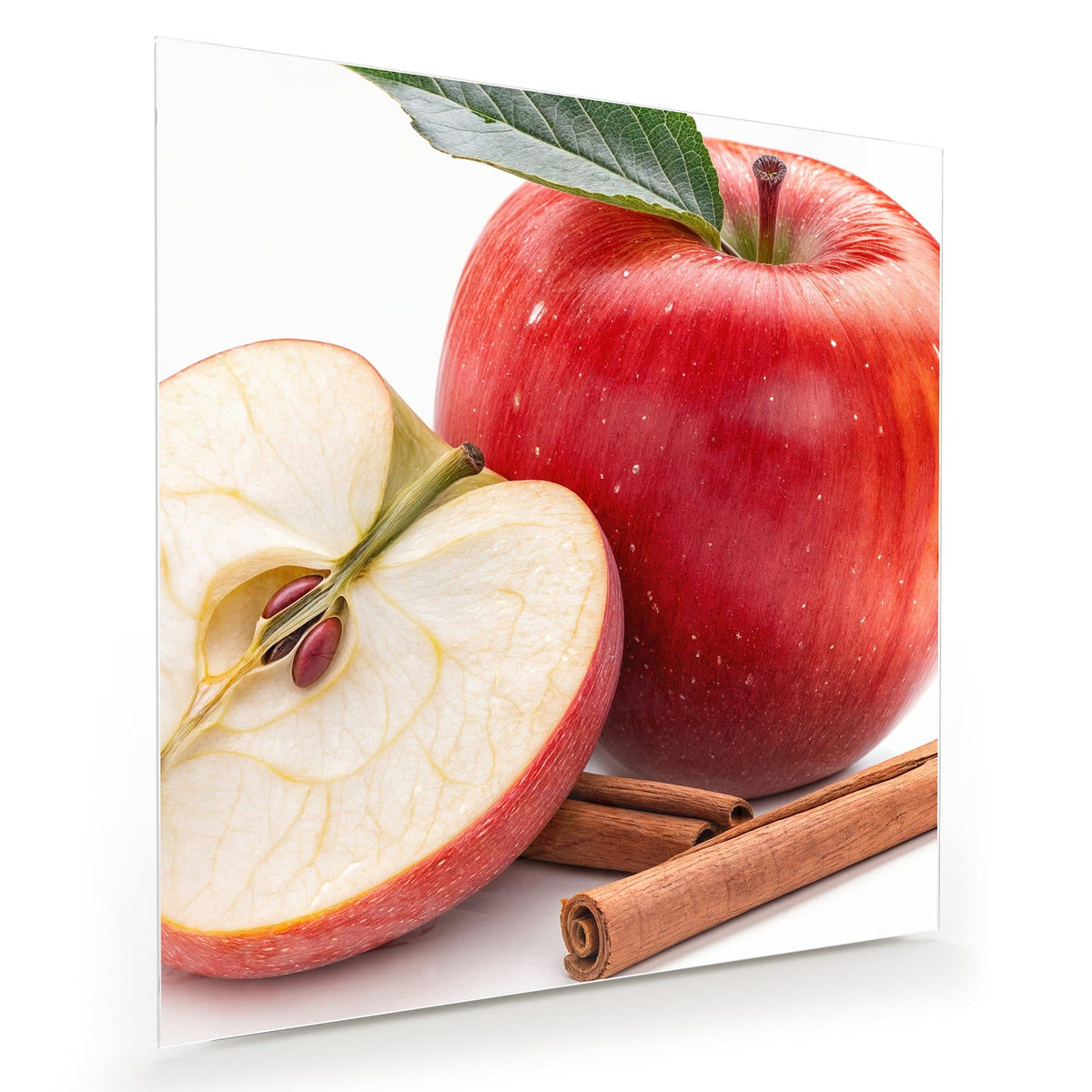Ganzer roter Apfel mit Blatt, daneben eine halbierte Apfelhälfte mit Kernen und zwei Zimtstangen