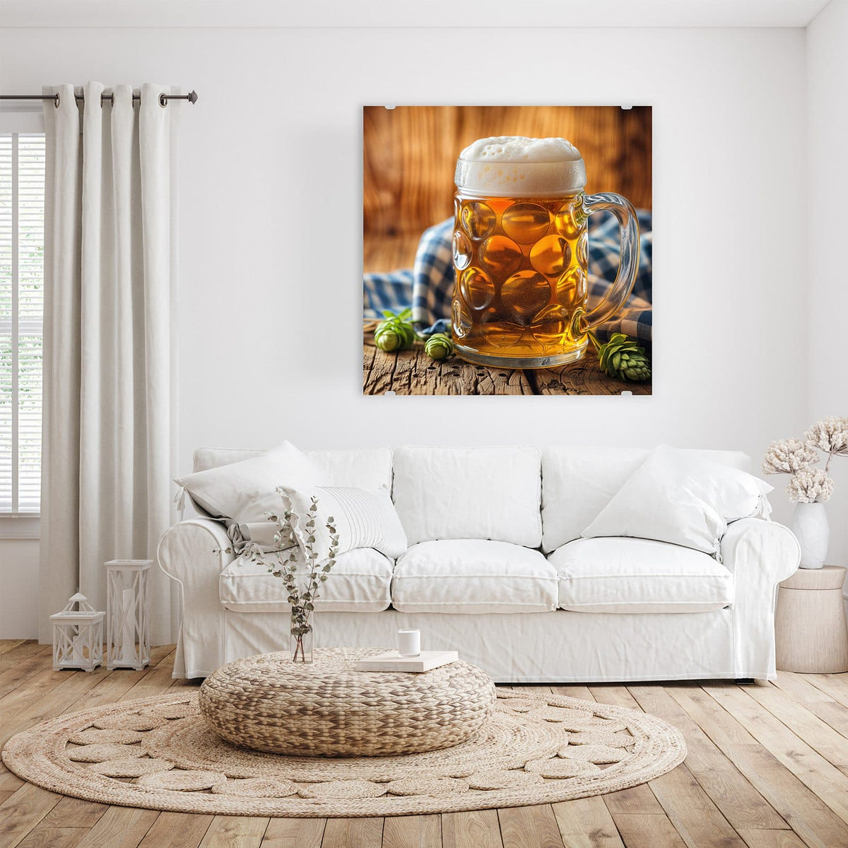 Glasbild Bayerisches Bier an der Wand – Gedellter Glaskrug mit goldenem Bier und hoher Schaumkrone, davor Hopfendolden, dahinter ein blau-weiß kariertes Tuch.