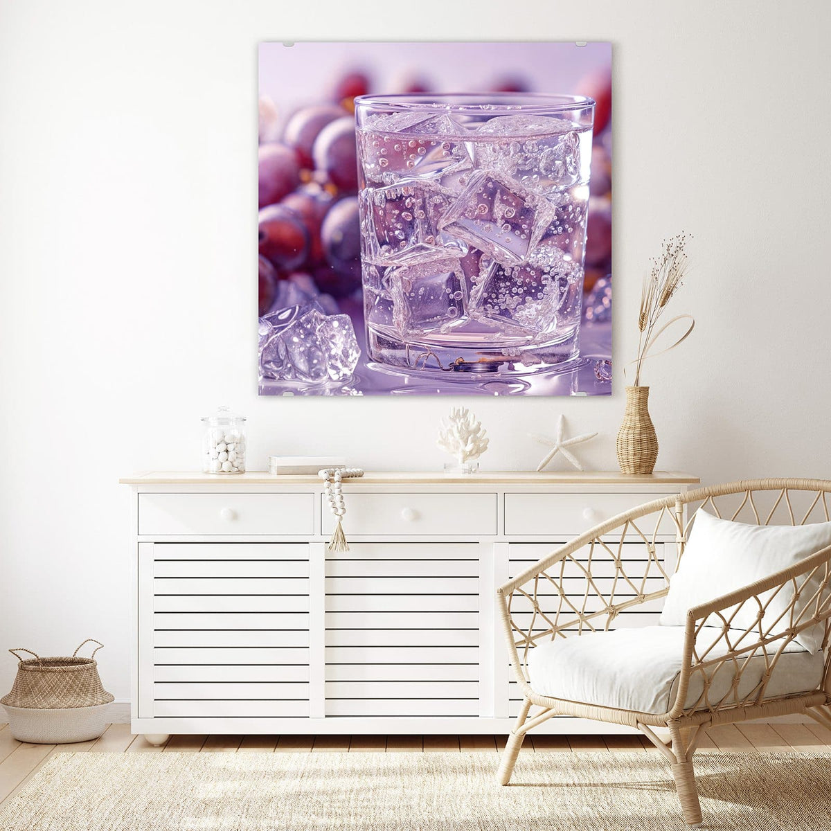 Glasbild Sprudel mit Trauben an der Wand – Glas mit klarem, sprudelndem Getränk und Eiswürfeln, dahinter dunkle Weintrauben in Lila
