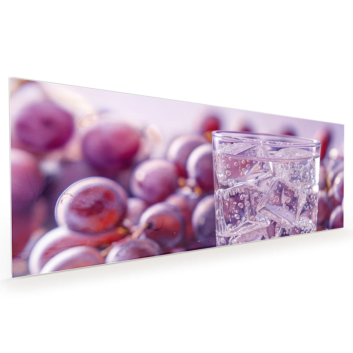 Küchenrückwand aus Glas im Hochformat mit Motiv Sprudel mit Trauben: Glas mit klarem, sprudelndem Getränk und Eiswürfeln, dahinter dunkle Weintrauben in Lila #grösse_40 x 100 cm #grösse_50 x 125 cm #grösse_60 x 150 cm