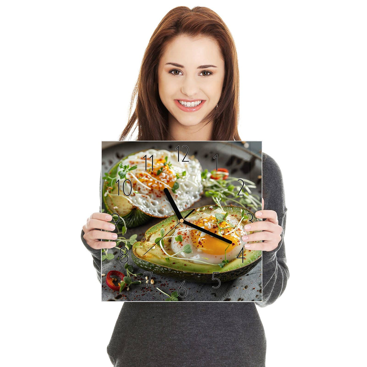 Zwei Avocadohälften mit darin gegartem Ei, Kresse, Chiliflocken und Sesam auf dunklem Teller.
