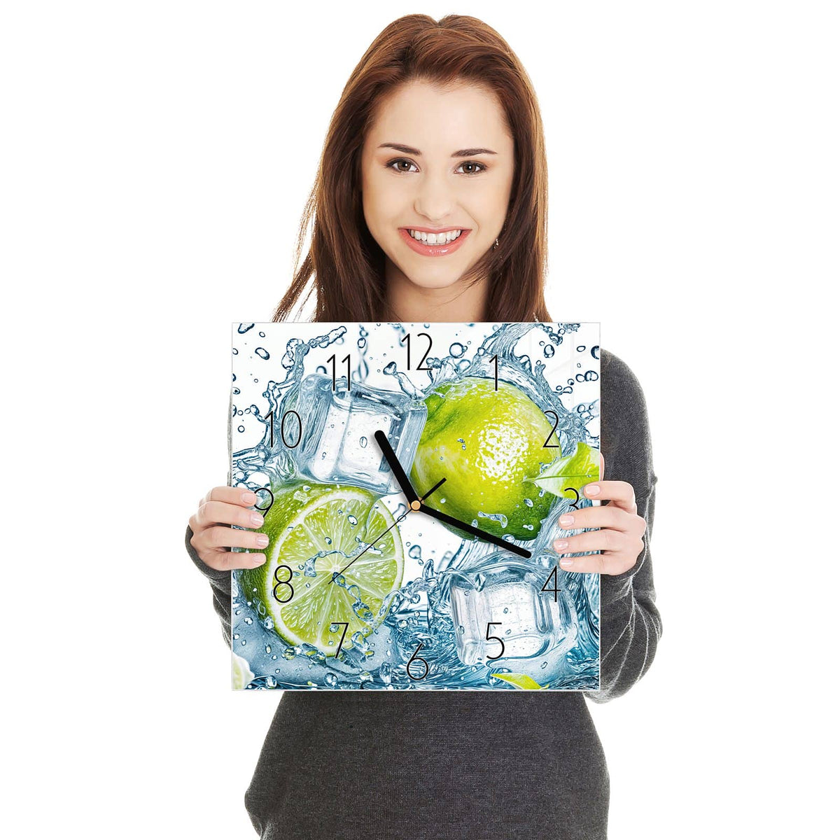 Ganze Limette, halbe Limette und Eiswürfel in aufspritzendem Wasser