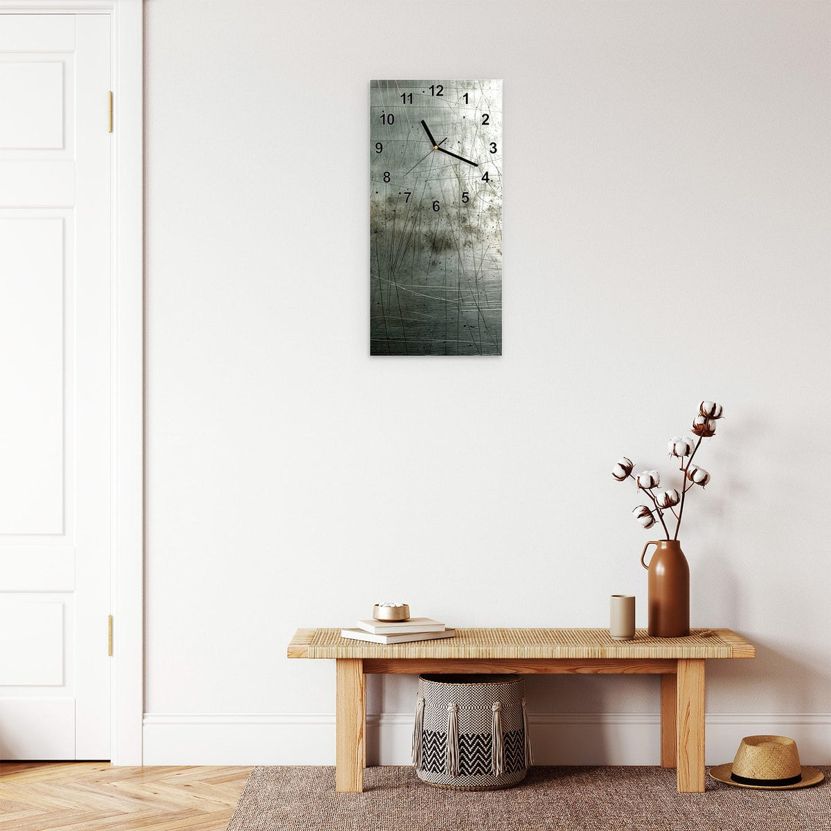Wanduhr aus Glas im Hochformat Zerkratzter Stahl mit Ziffernblatt Modern über einer Holzbank im Flur