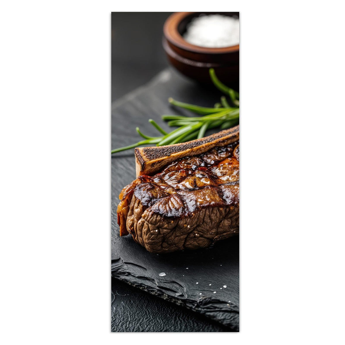 Angeschnittenes T-Bone-Steak mit Grillstreifen auf Schiefer, dazu Rosmarin, Salzschale und Pfefferkörner