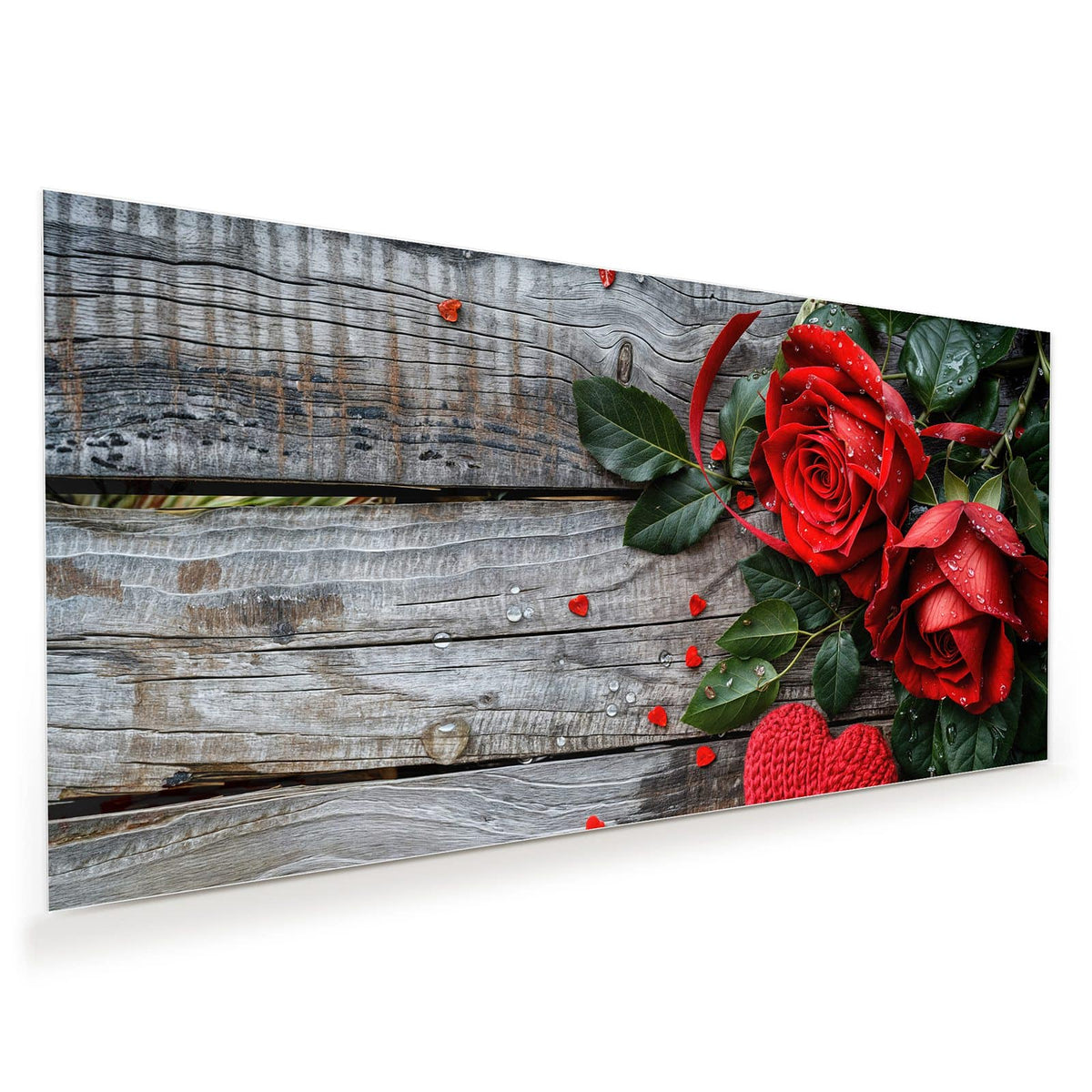 Zwei betaute rote Rosen auf grauem Holz, davor ein rotes und ein beiges Strickherz