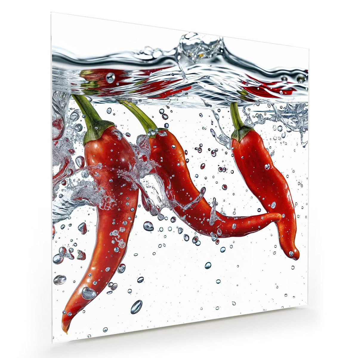 Drei rote Chilischoten sinken unter die Wasseroberfläche, Luftblasen ringsum, weißer Grund