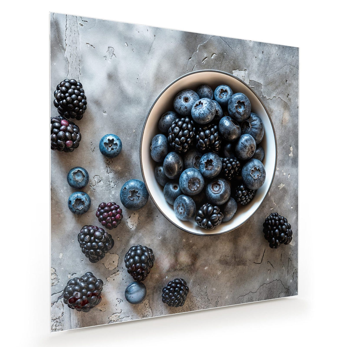 weiße Schale voller Blaubeeren und Brombeeren auf grauem Beton